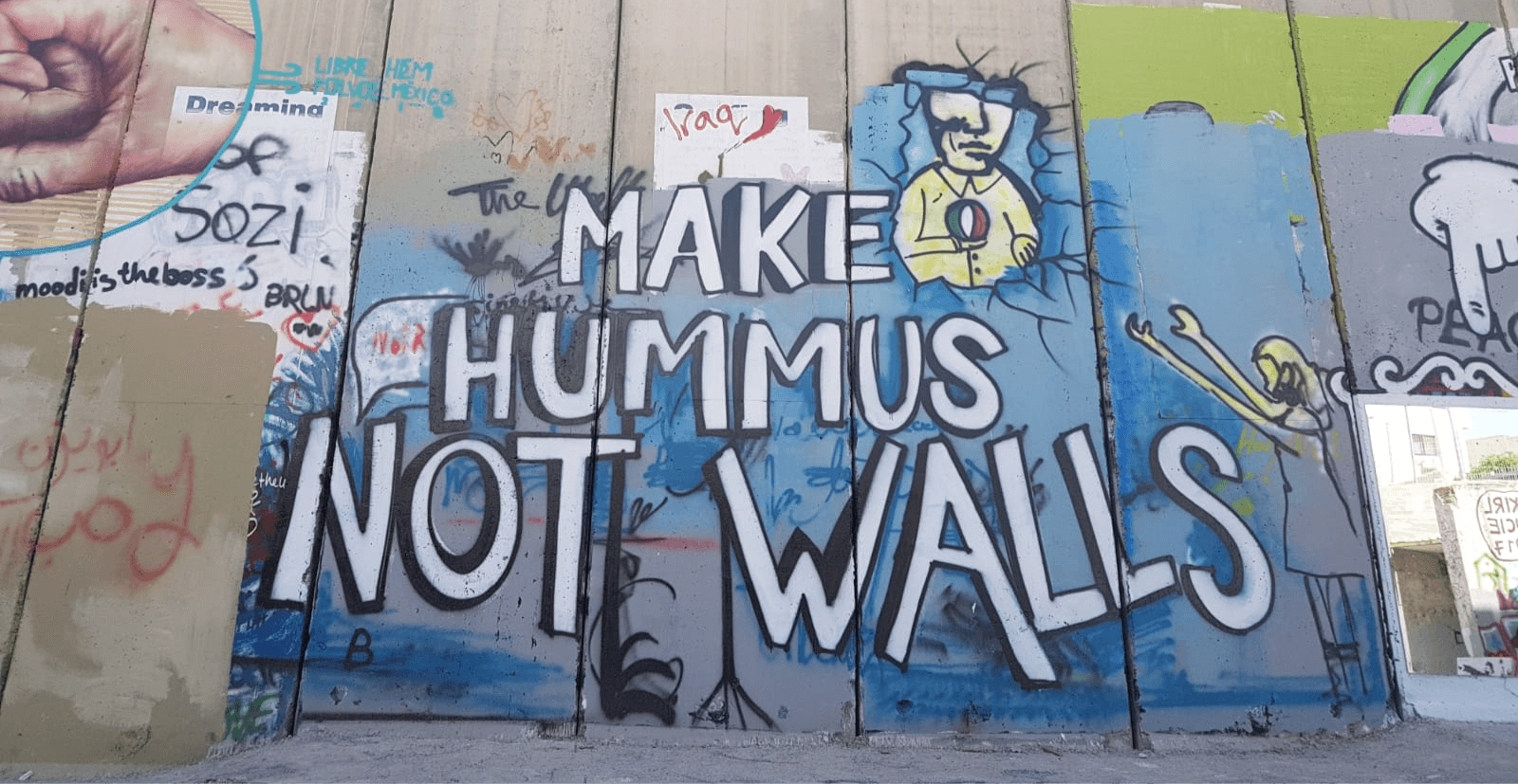 Graffiti of "make hummus not walls" in reference to local cuisine and ongoing Israel-Palestine issues