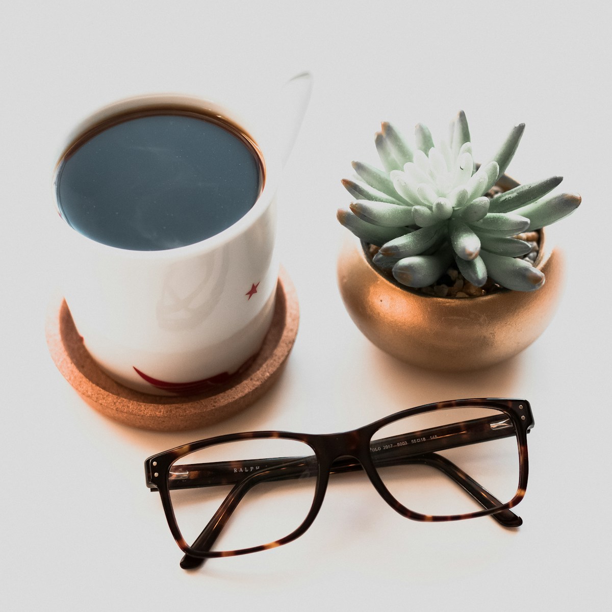 Eyewear still life with coffee and plant