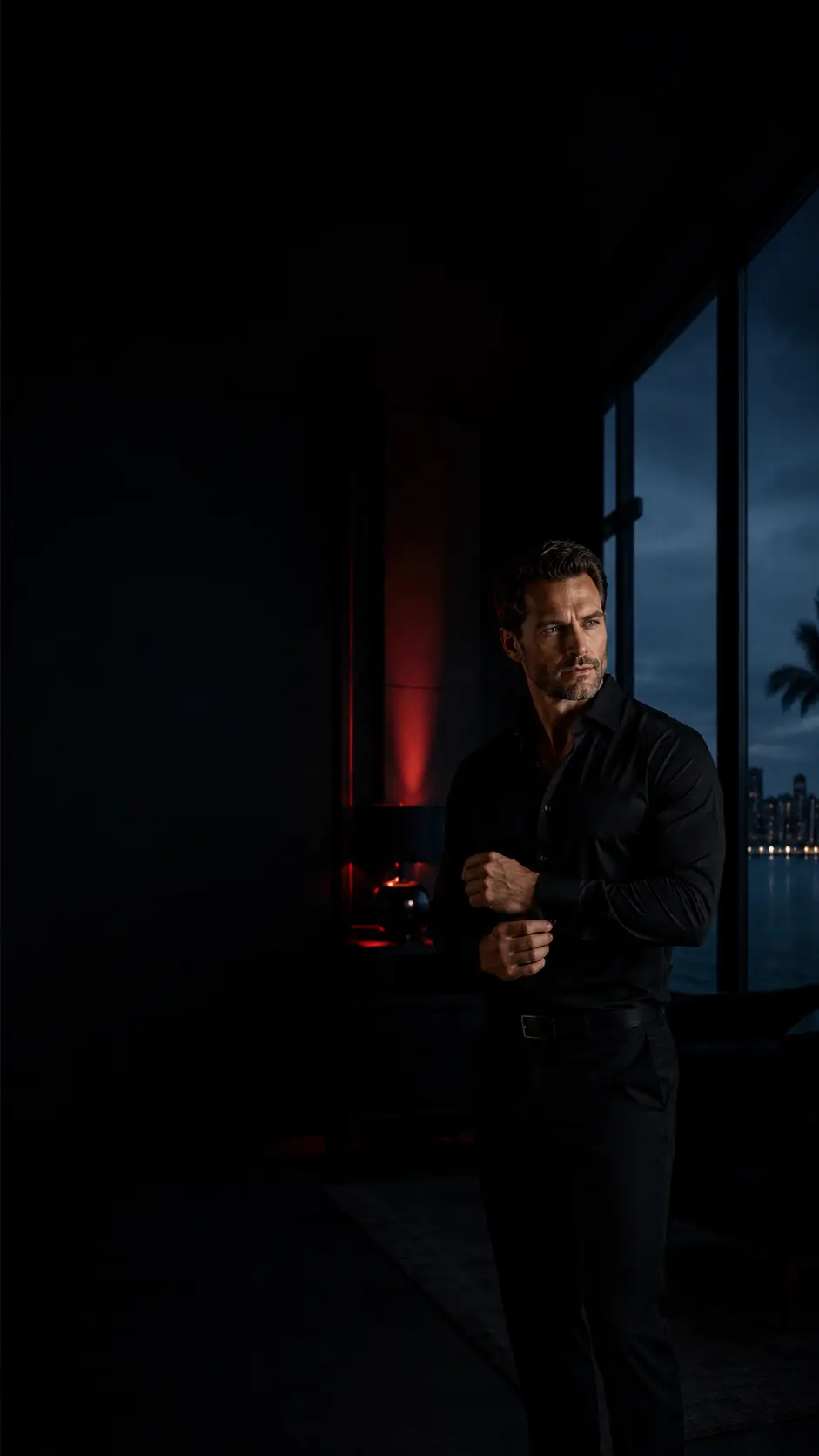 Man in dark clothing in a dimly red-lit room