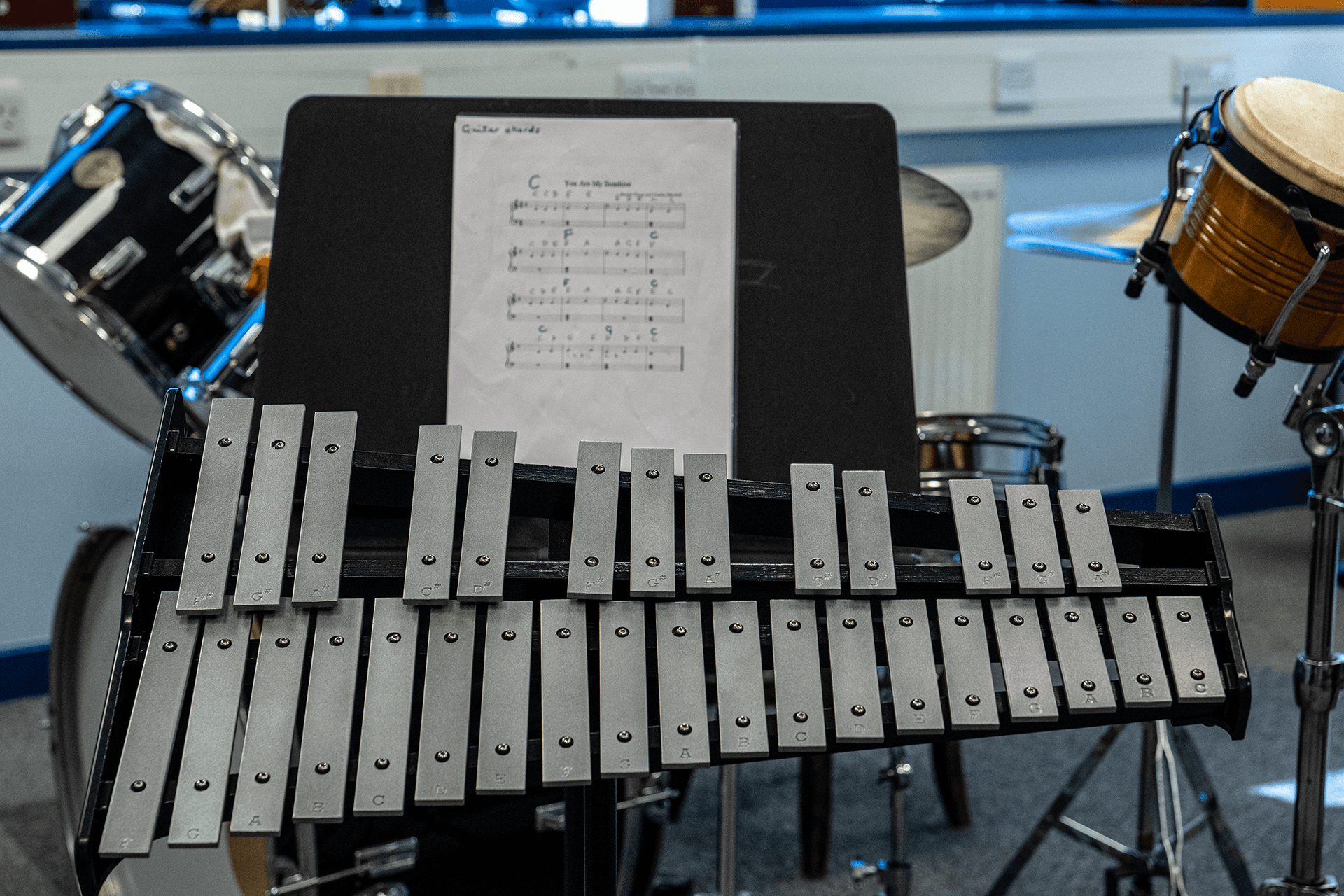 Musical score placed next to a xylophone, ready to be used in a music practice session