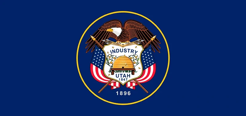 Flag of Utah: Features a bald eagle atop a shield with US flags, a beehive, and "Industry" and "Utah 1847 1896." The background is dark blue.
