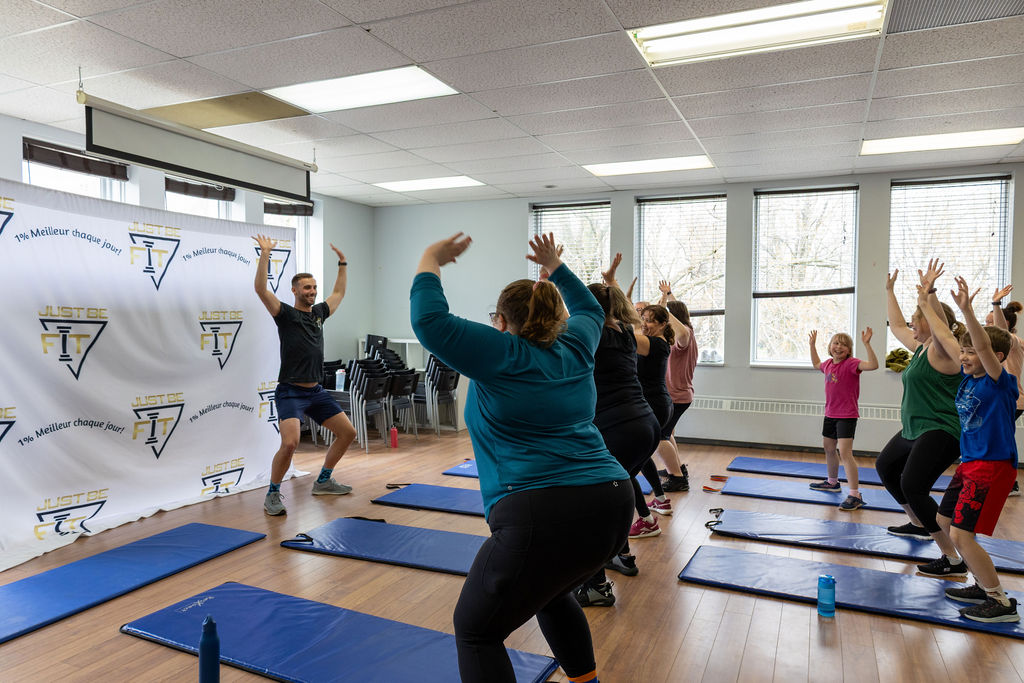 Étienne Gillard, kinésiologue, anime un cours de groupe dynamique pour les femmes du programme Progrès-Fit sur des tapis d'entraînement.