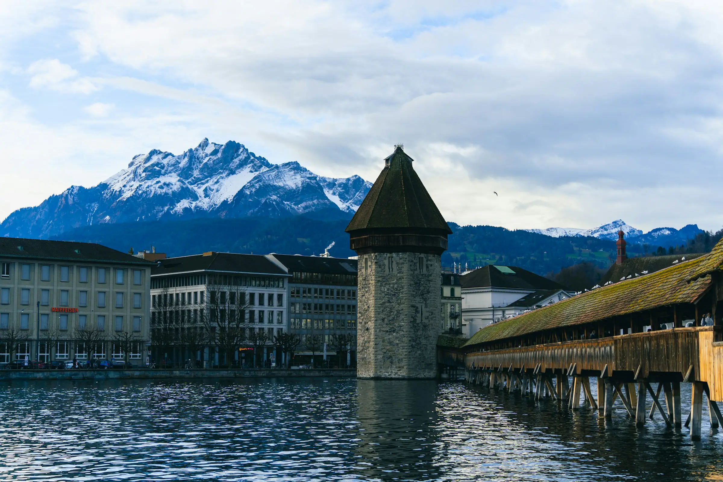Luzern, Wasserturm und Kapellbrücke an der Reuss mit schneebedecktem Pilatus