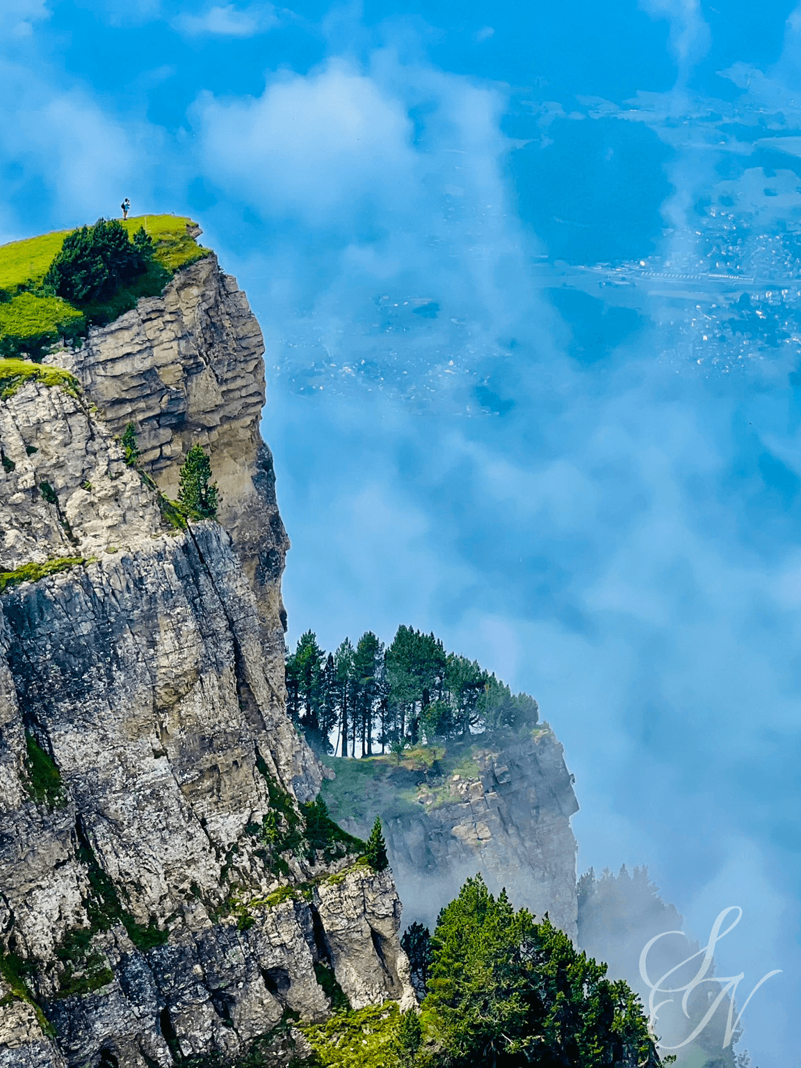 Dramatic Swiss cliffs of Niederhorn. A person standing on the top of the cliff.