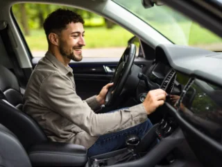 Homme souriant au volant après avoir récupéré son permis de conduire grâce à un accompagnement juridique spécialisé