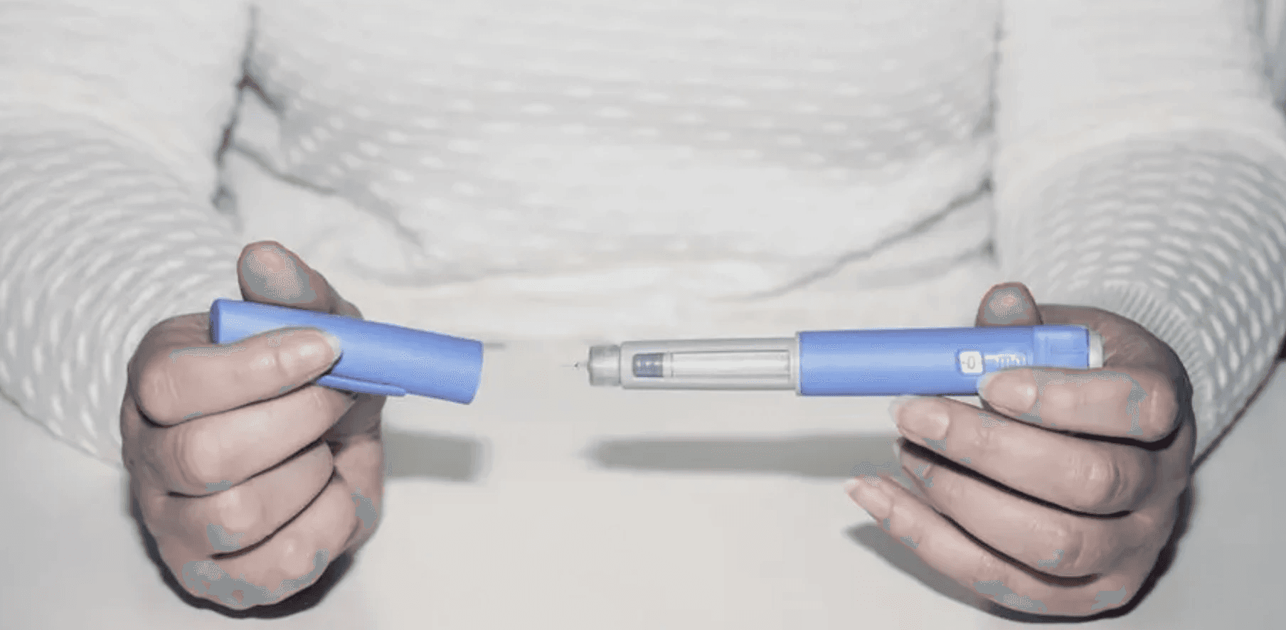 Person holding blue medical injector pen - Compounded Semaglutide Side Effects