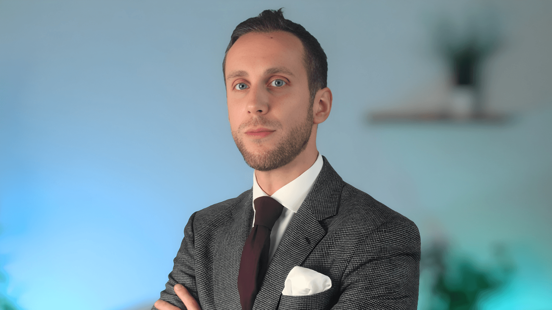A woman with short curly hair wearing a black t-shirt looks into the camera.