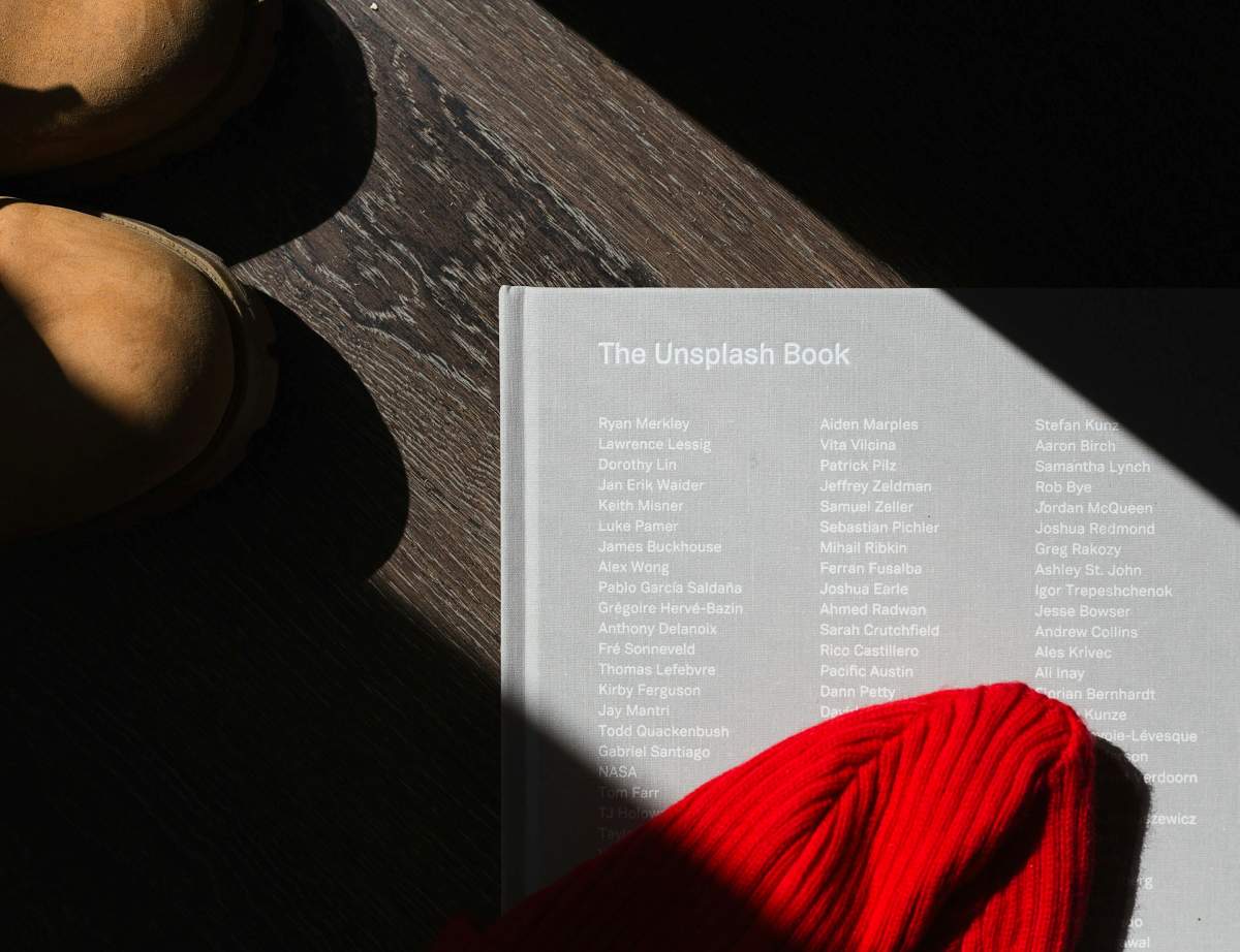 The Unsplash book photo laying on the wooden table.
