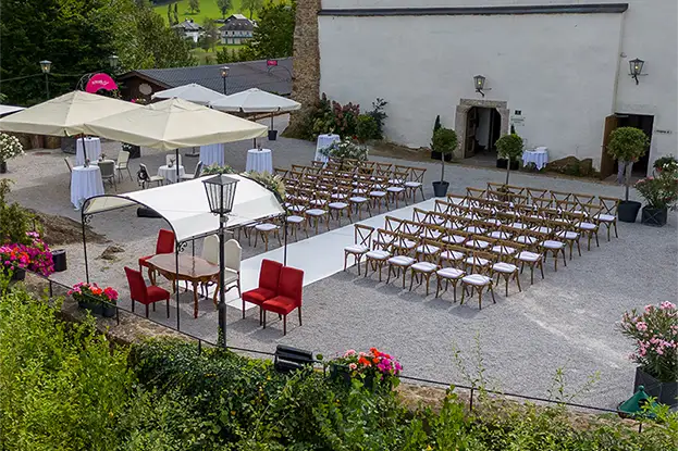 A three-tiered wedding cake adorned with soft pink roses and delicate floral arrangements against a bright background.