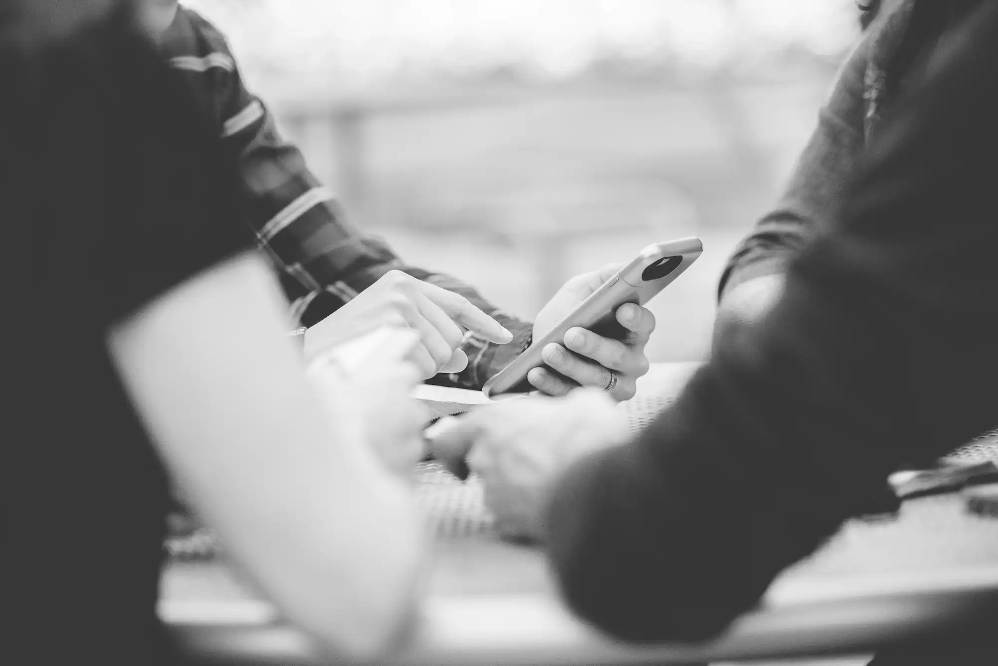 Menschen die auf ein Handy tippen und sich Kontaktdaten geben