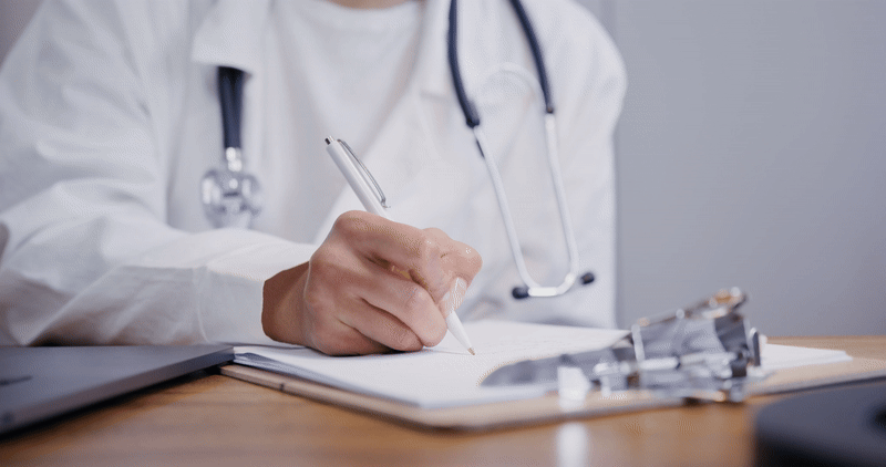 Doctor writing down on notebook