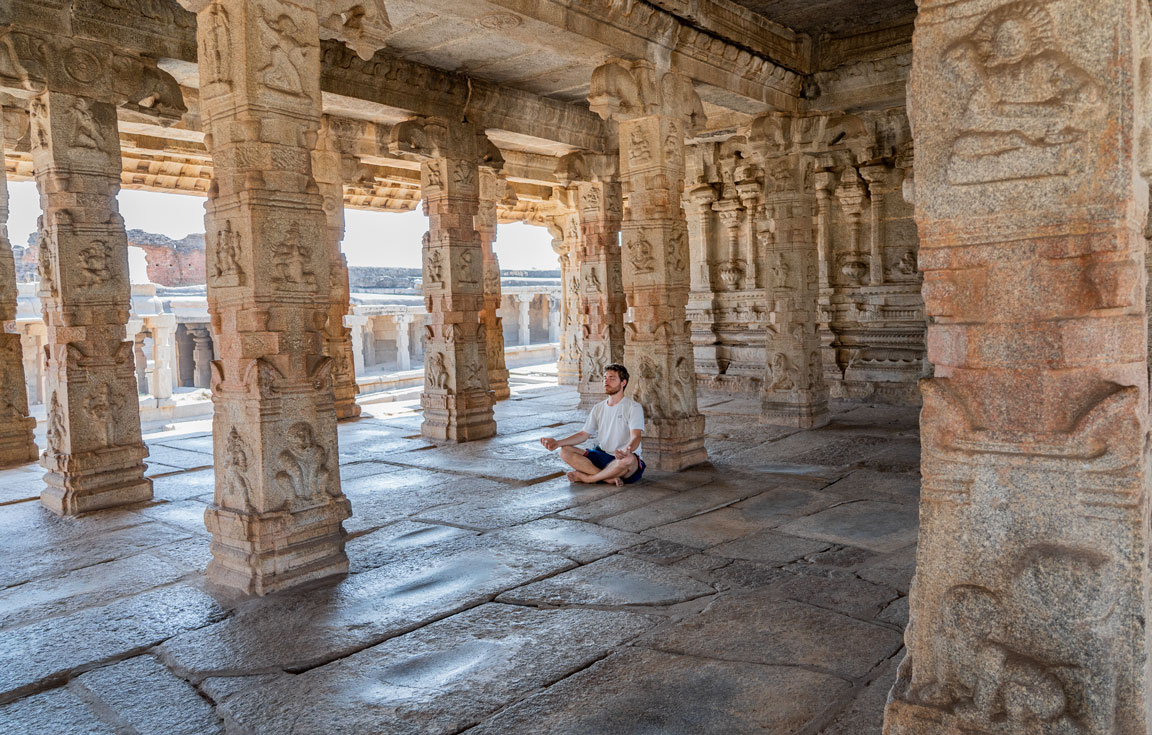 Pit meditating between the columns of the Krishna Temple in Hampi