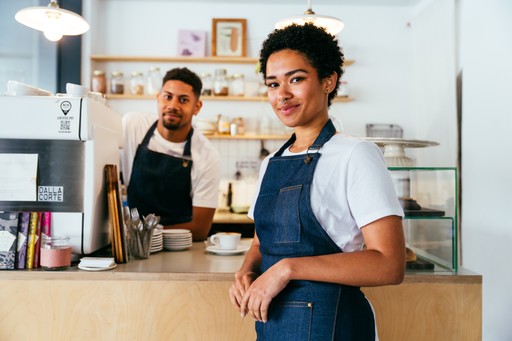 A maroon passport, a credit card, and a document are placed on a dark surface.