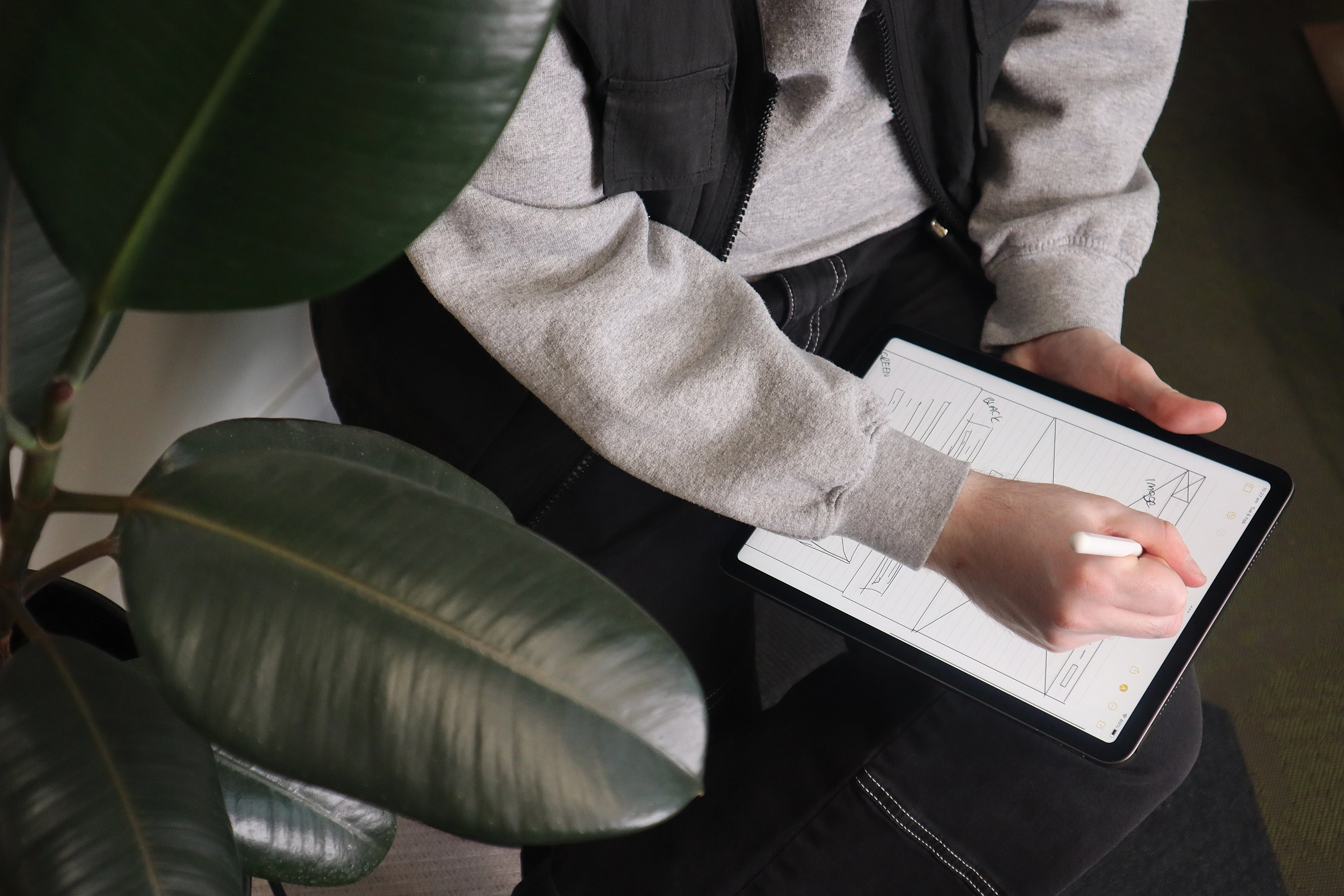 Launch employee shown from above wireframing a website on their ipad.