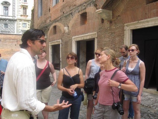 A photo of a group of people visiting old buildings in Rome.