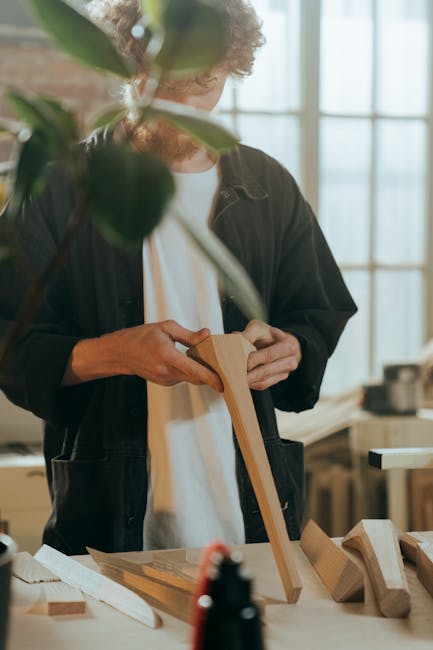 A craftsman expertly working on wooden materials in a well-lit indoor workshop setting.