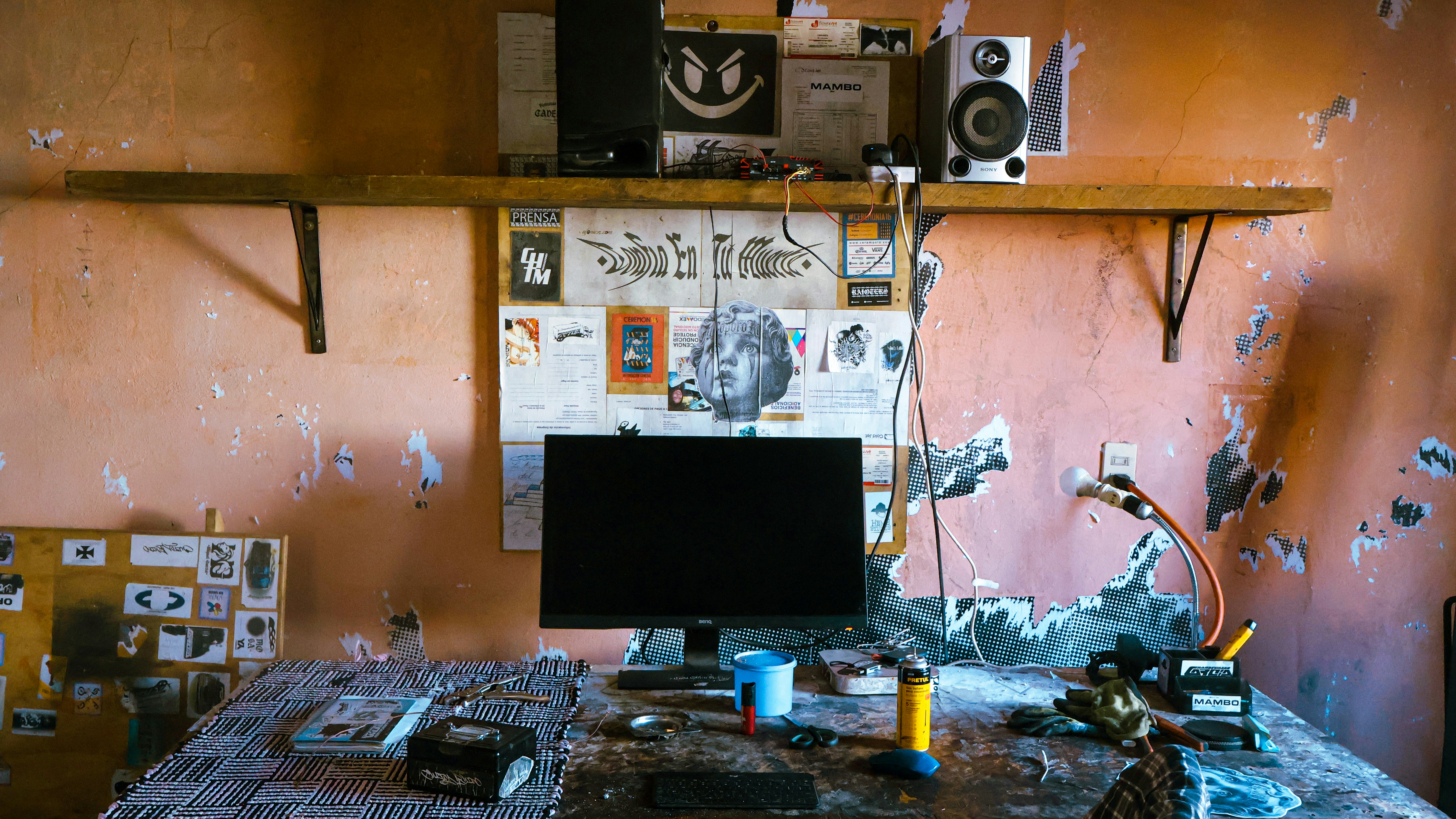 A cluttered desk with a computer monitor and speakers.