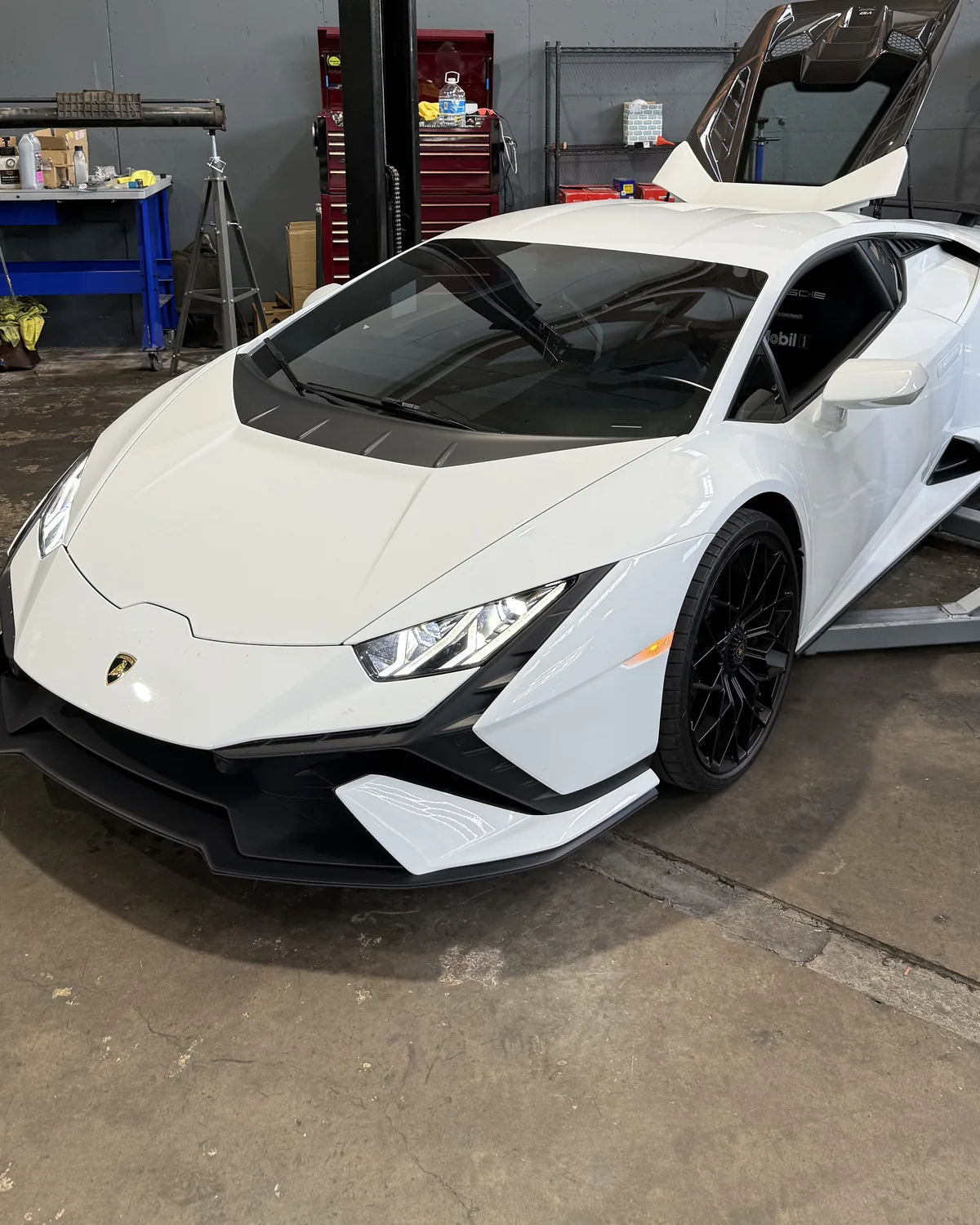 White Lamborghini Huracán with its engine cover raised in the 714 Technik service bay