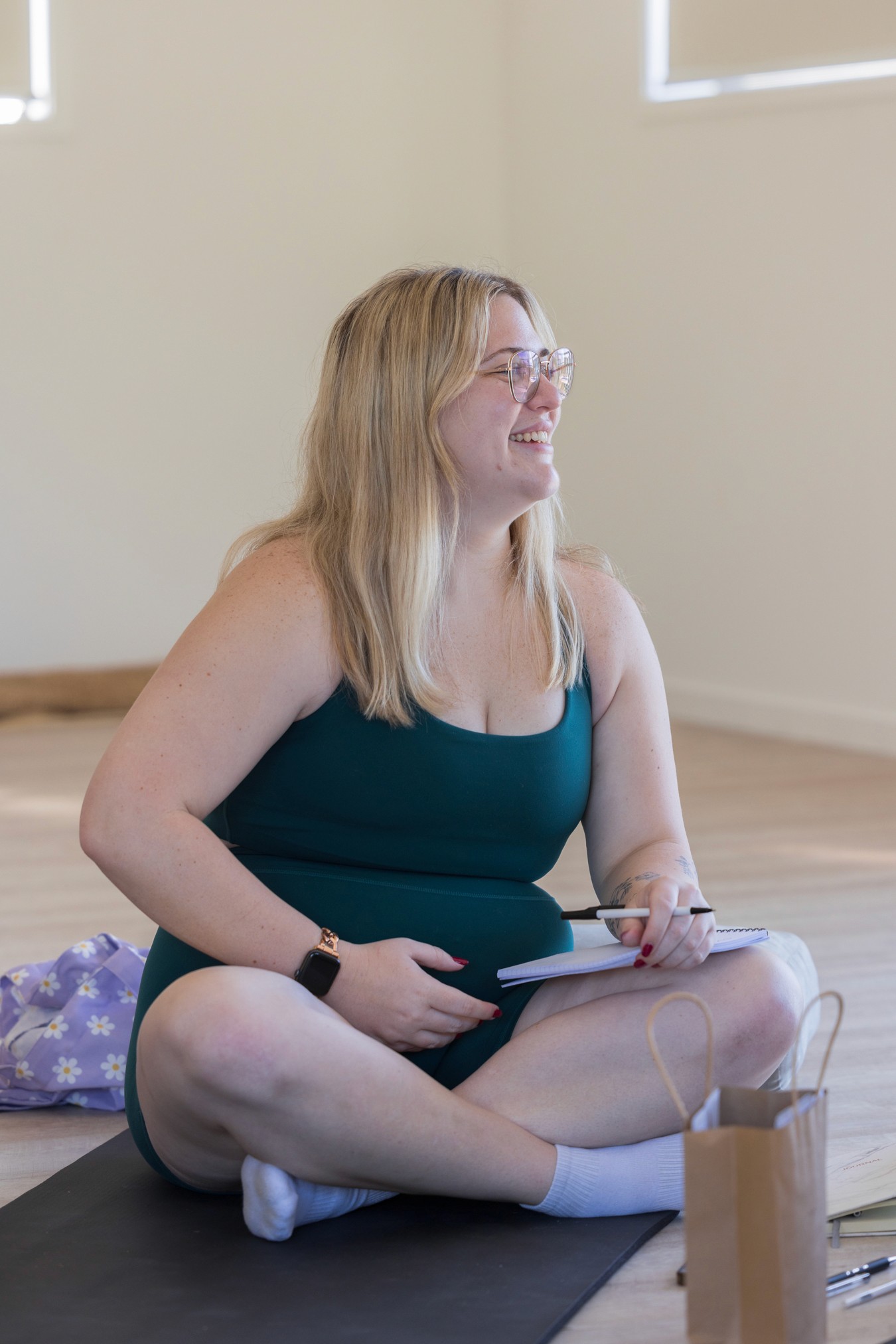 Woman sitting cross legged in a room smiling