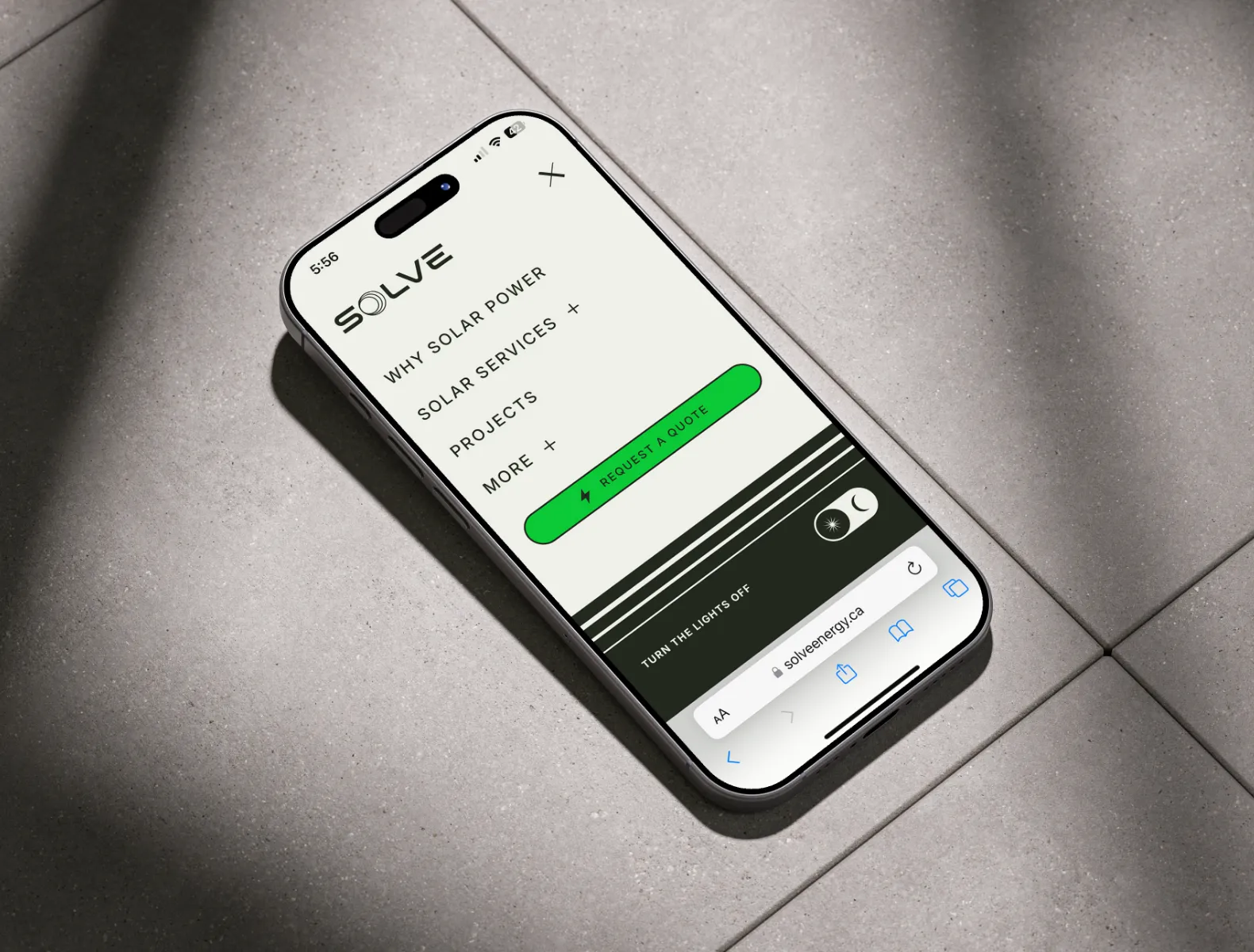 A mockup of the Solve Energy website menu on an iPhone sitting on floor tiles.