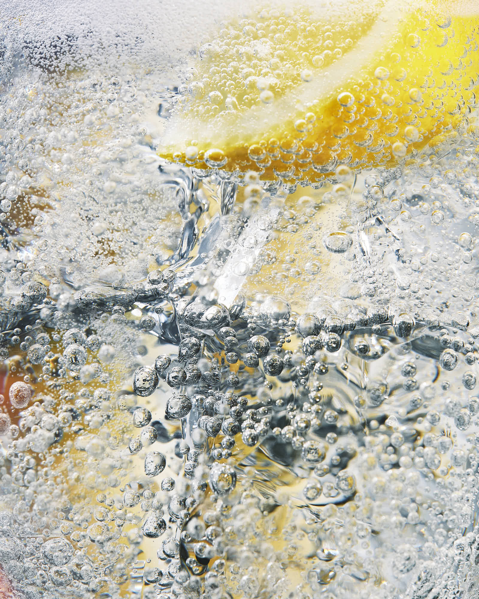 Closeup of fizzy drink macro with lemon wedg