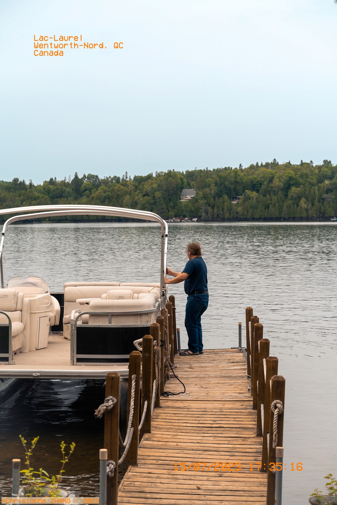 Personne attachant un bateau au quai avec une vue sur le lac Laurel en arrière-plan.
