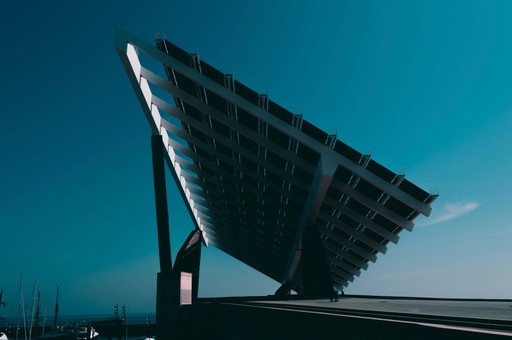 A large solar panel stands against a clear blue sky, showcasing modern renewable energy technology.