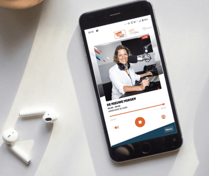 Cover afbeelding van een mobiel met oortjes ernaast en een app open van Groot Nieuws Radio