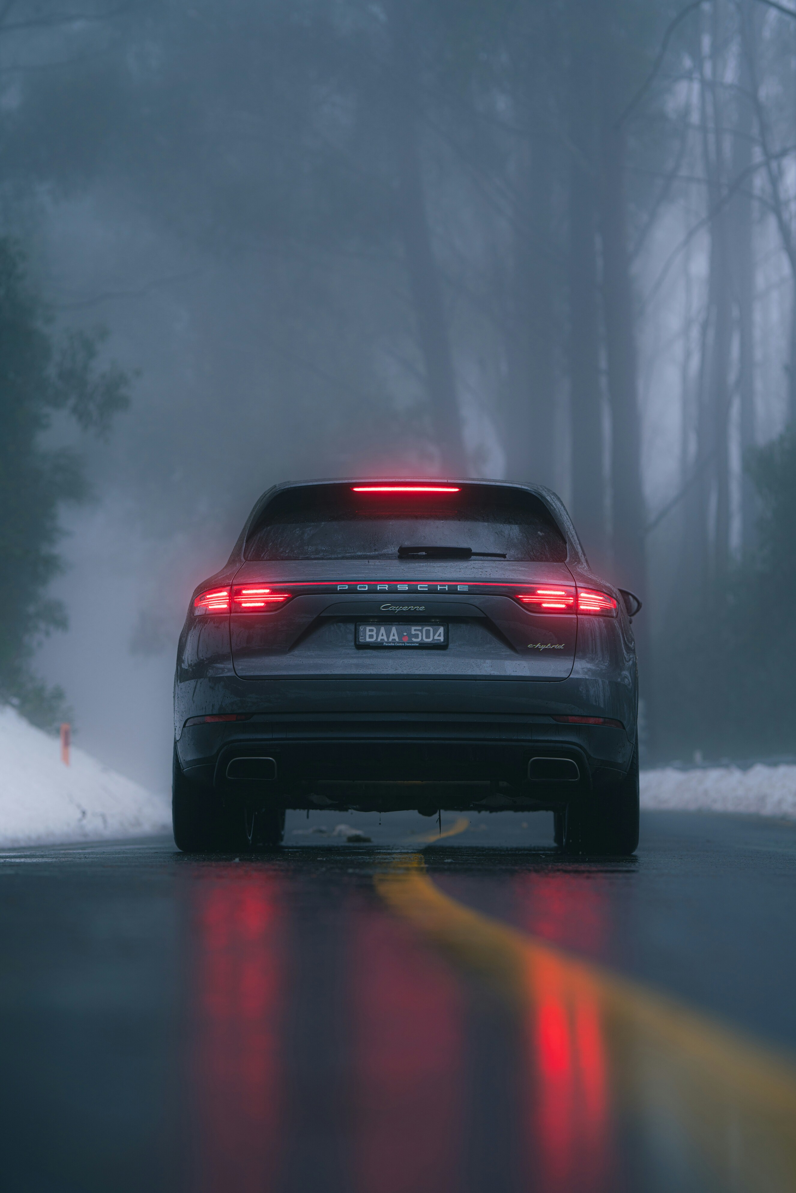 black car on snow covered road during daytime