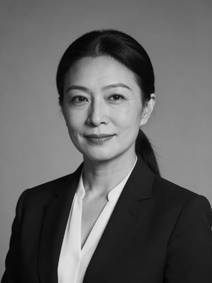 Professional portrait of a woman in formal attire, featuring a neutral background and a confident expression.