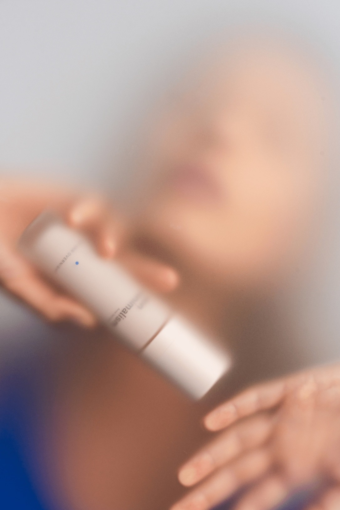 Sesja zdjęciowa dla Skin Minimalism – rozmyty portret kobiety trzymającej produkt marki Skin Minimalism