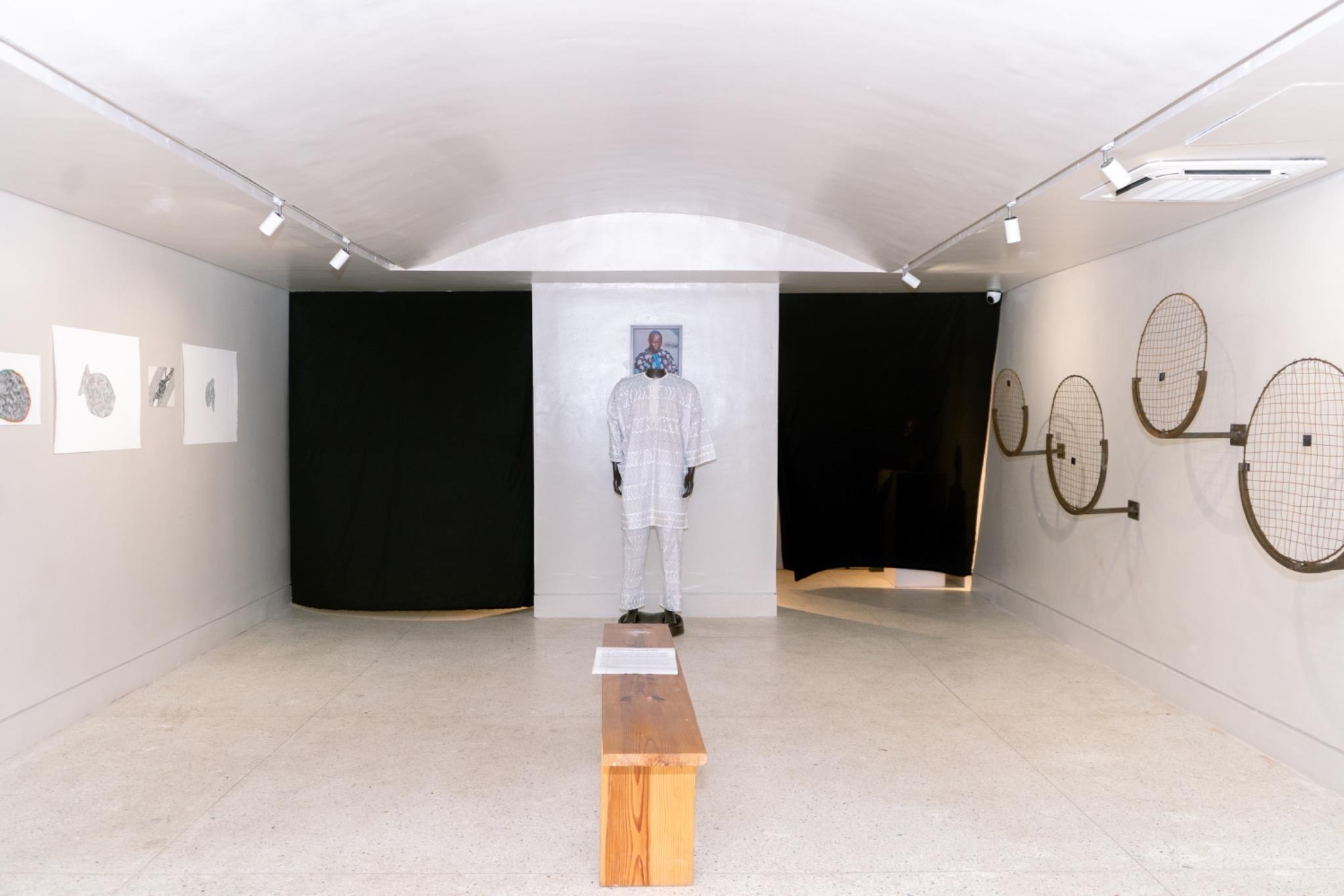 Installation view of Ka ọ dị mgbe anyi g’afu ozo (Until We See Next Time) at CCA Lagos, showing works arranged across the gallery walls and central floor area.