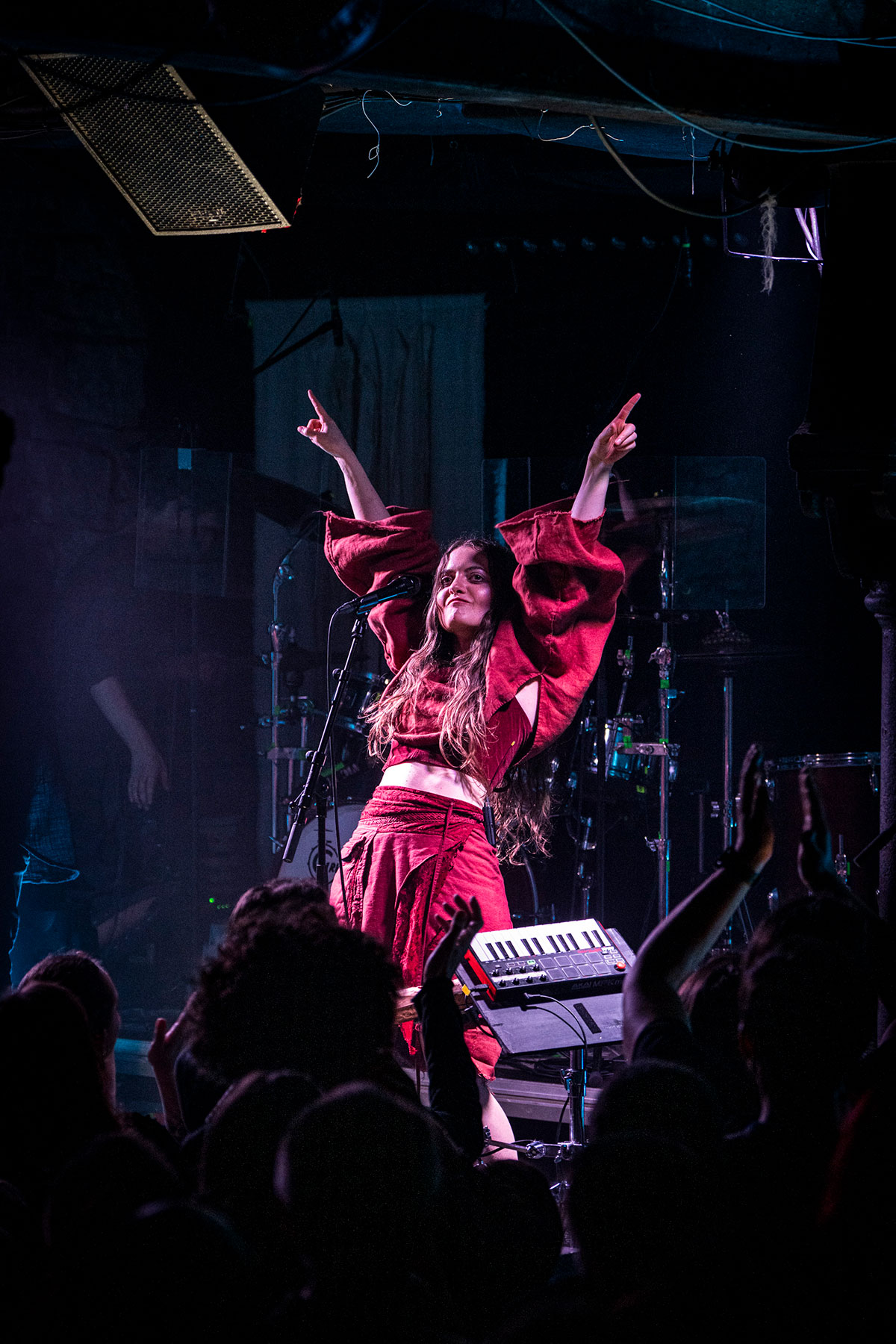 Singer performing live on stage during a concert, captured with dynamic stage lighting.