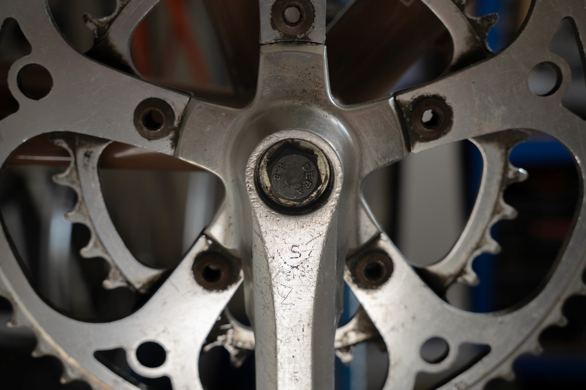 A close up of a person working on a bike crankset