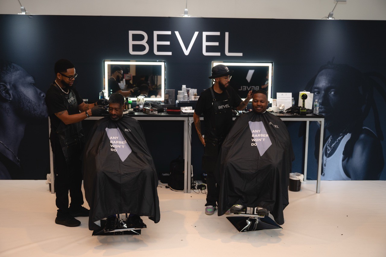 Two barbers provide haircuts at the BEVEL grooming lounge during Omega Psi Phi’s 85th Grand Conclave.