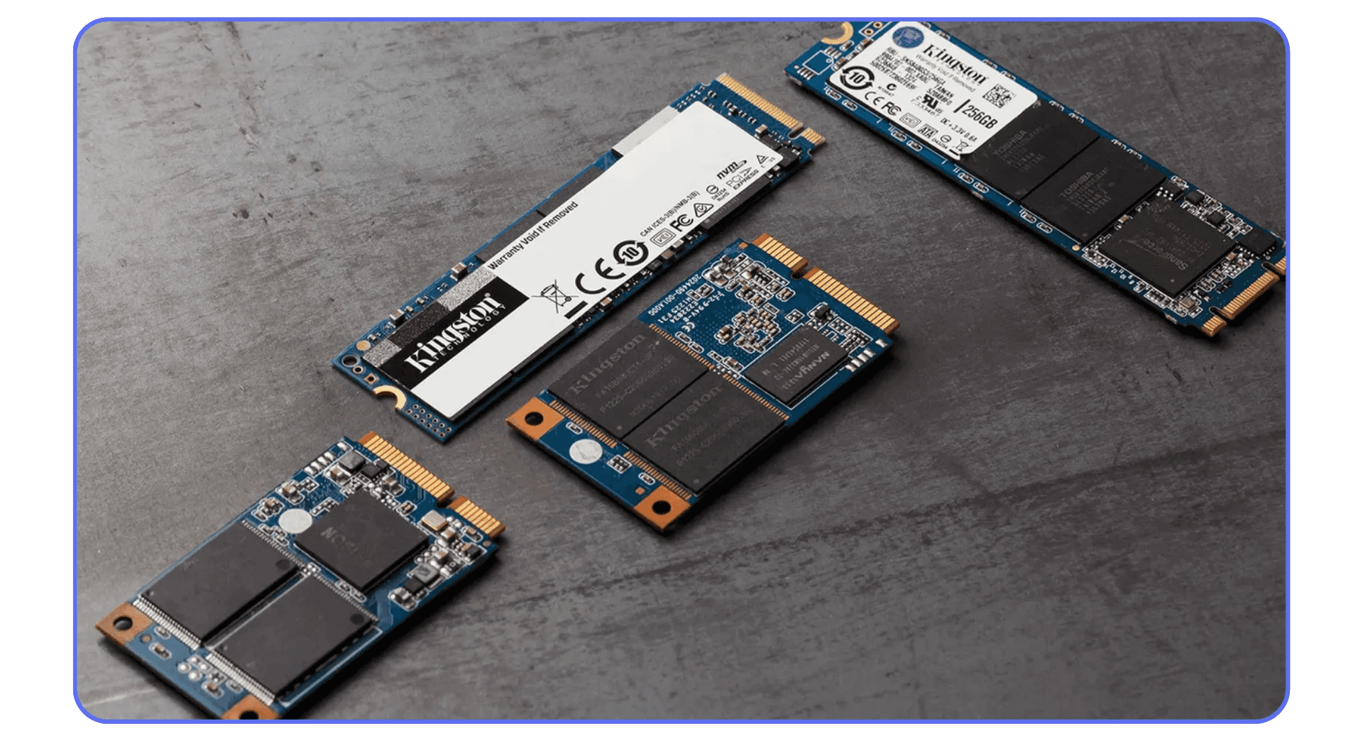 Several M.2 and SATA solid-state drives (SSDs) of different sizes and brands laid out on a gray surface.