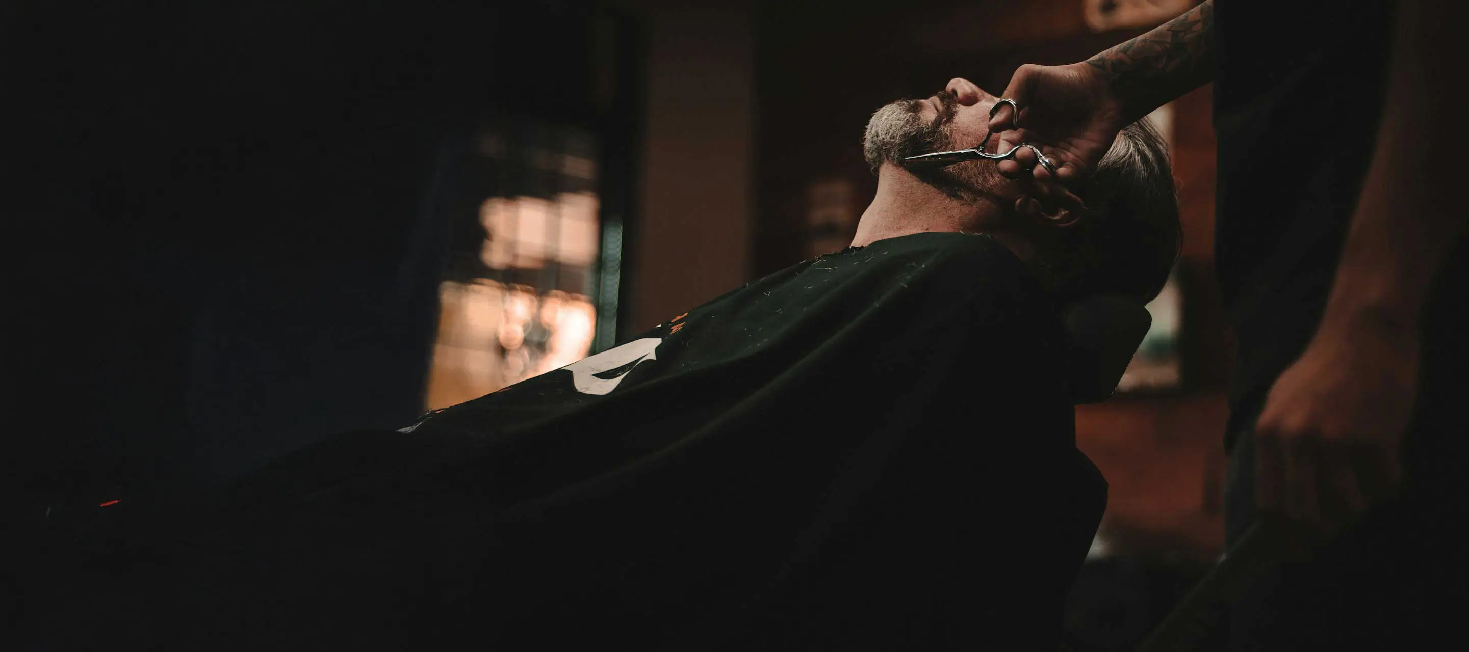 Lyon sitting at the client seat in a Barber Shop