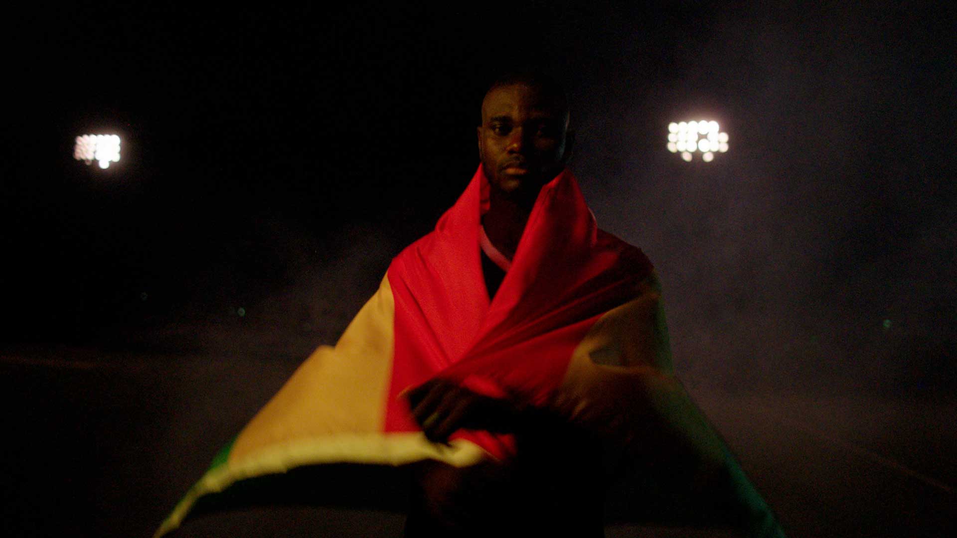Professional athlete Jonathan Mensah standing in golden hour light for Boss Money video