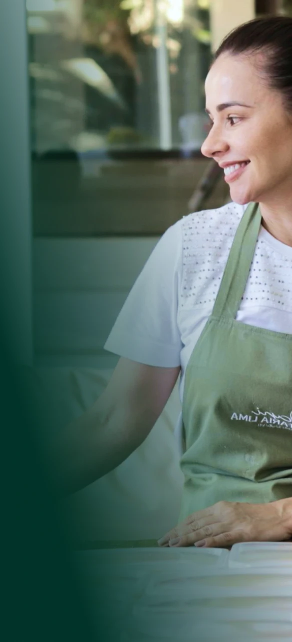 Foto da Dani sorrindo na cozinha - Hero