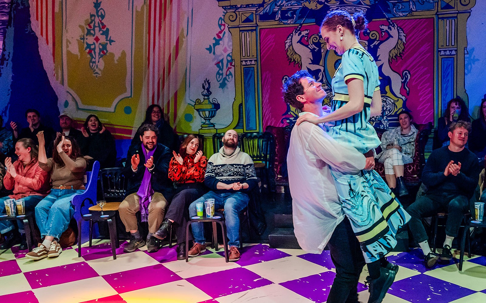 一对情侣在充满活力的剧院表演《舞步与偏见》时在观众面前跳舞。