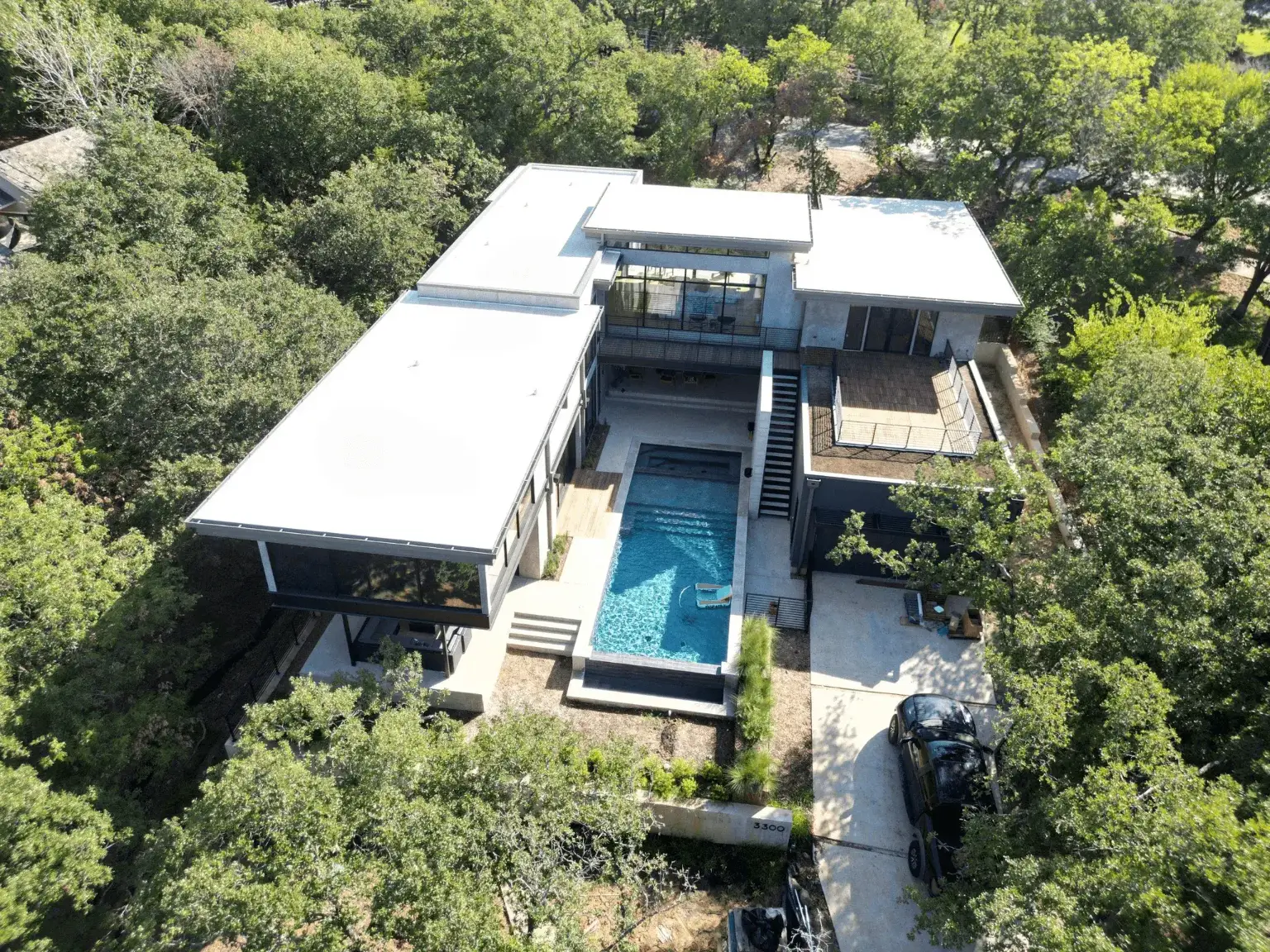 Modern home with pool and trees surrounding