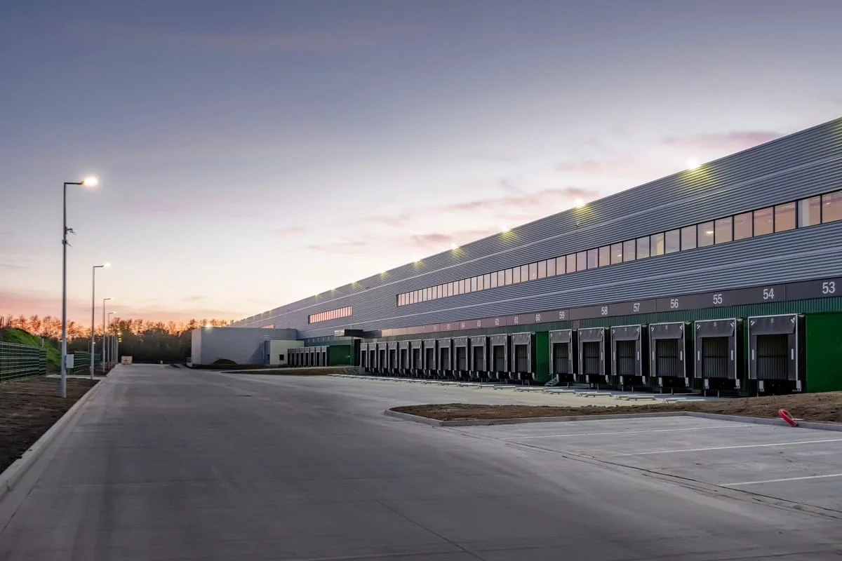 Entrepôt logistique au coucher du soleil avec zone de livraison – photographie d’entreprise Lille métropole 2025