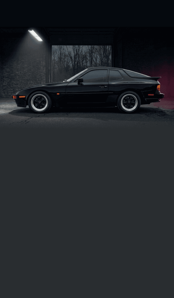 1985 Porsche 944 sitting in a parking lot at night.