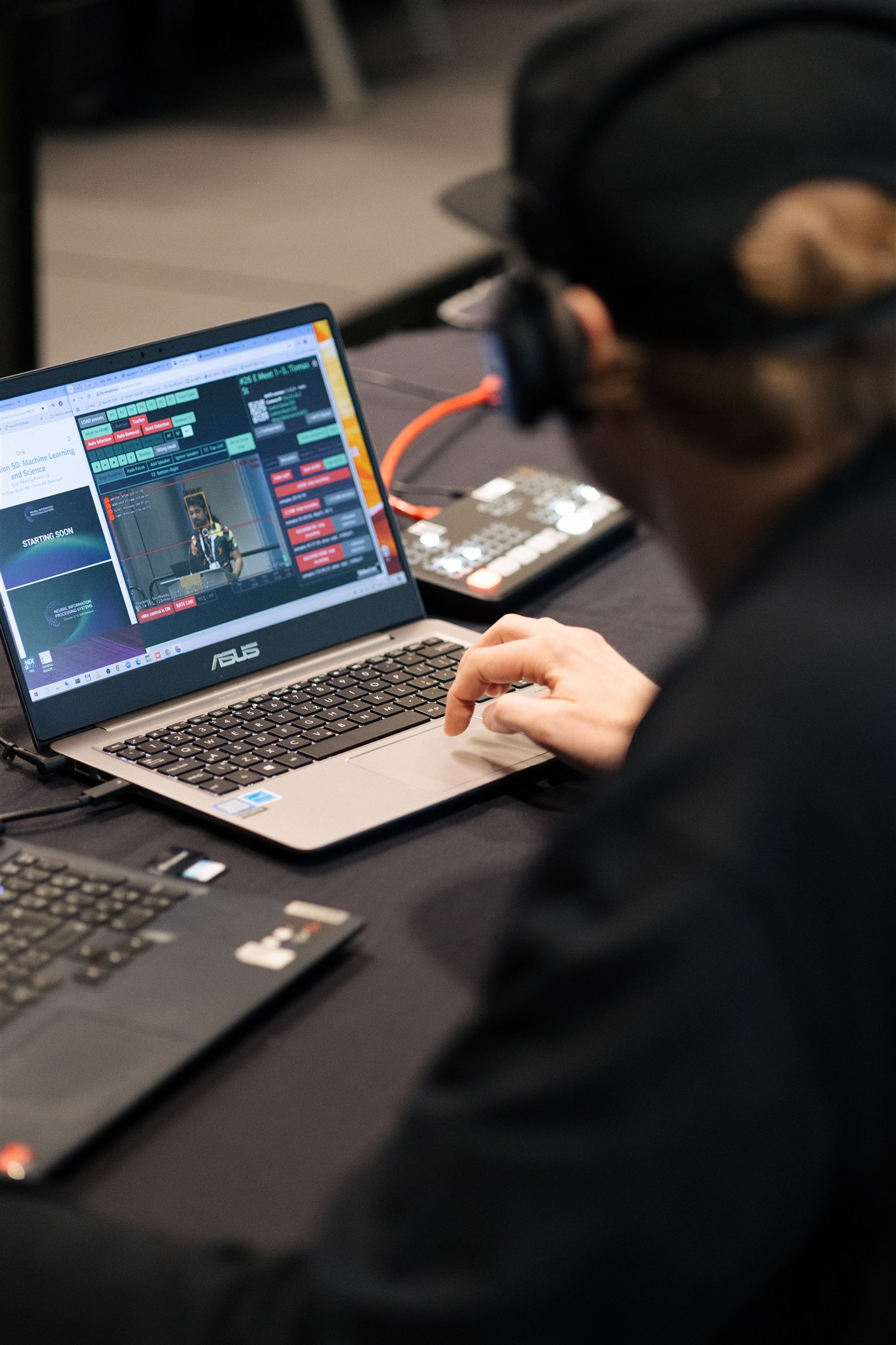 SlidesLive technician monitoring a speaker on a laptop during a live session.