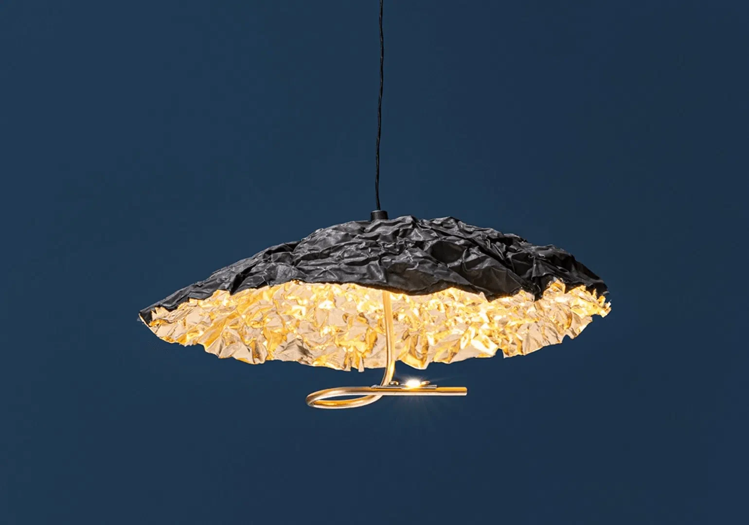 Lampara de techo Gold Moon de Catellani and Smith mostrando su acabado espectacular en pan de oro en el interior mientras que en el exterior un acabado oscuro y rugoso completan esta pieza de iluminacion escultorica.