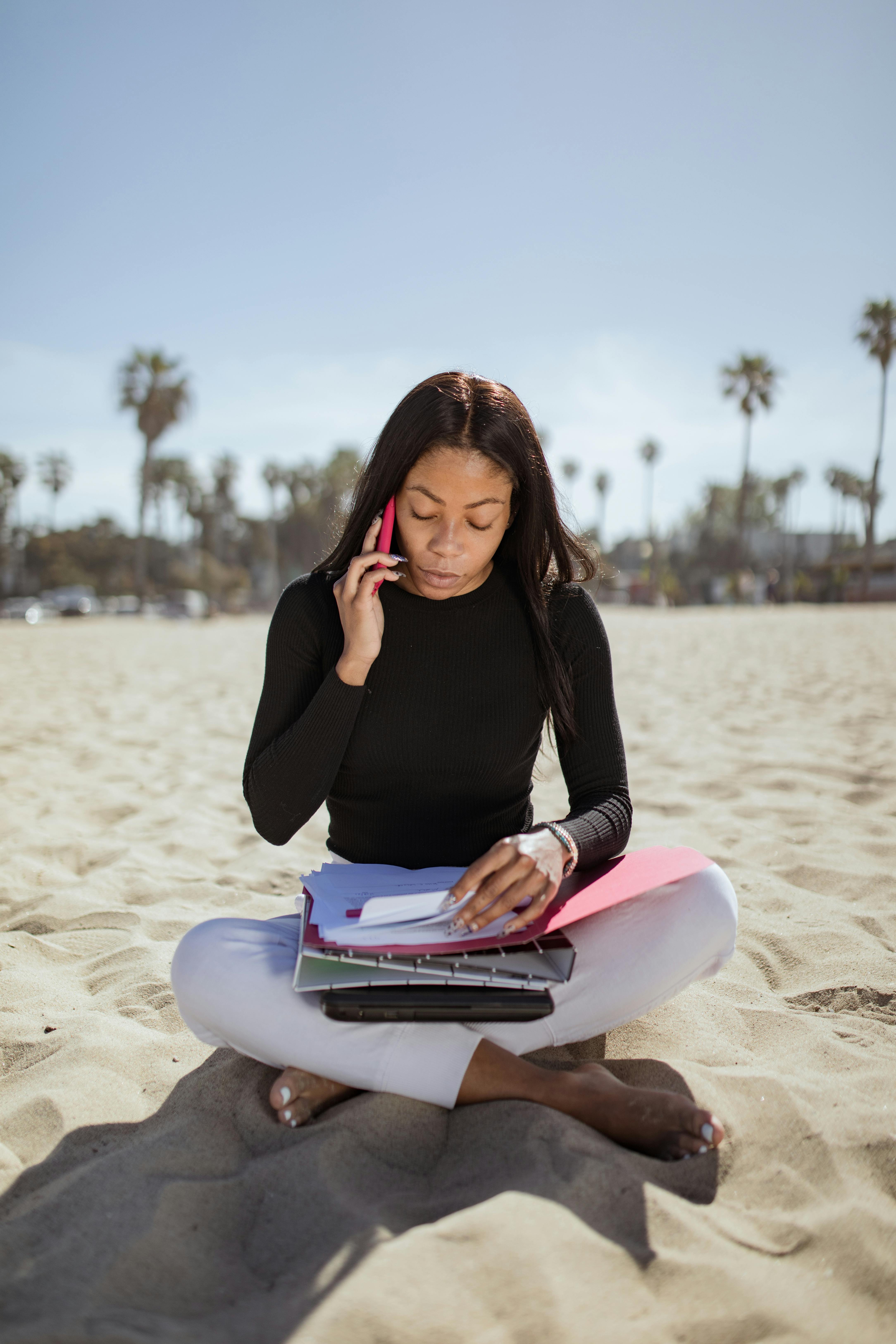 A smiling young man with crossed arms, wearing a plaid shirt and white t-shirt, poses against a dark background.