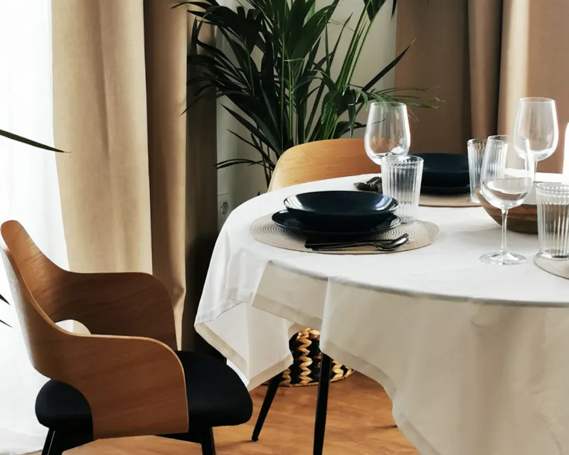 Wunderschön gedeckter Esstisch mit natürlichem Licht und Grünpflanzen in La Hipotenusa Tarifa