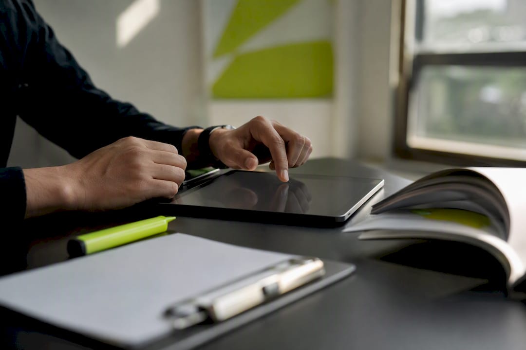 Hands auditing campaign naming on tablet and notes