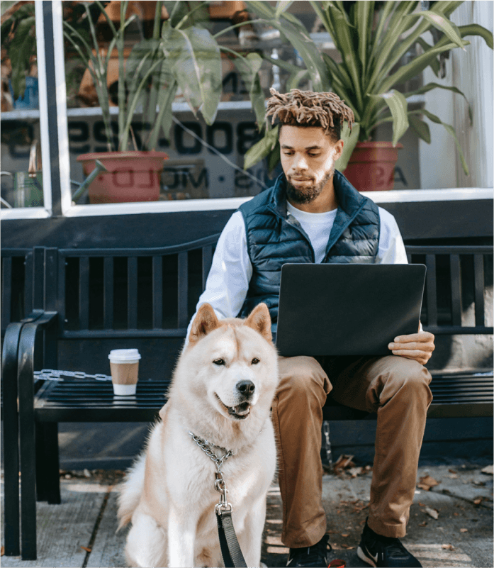 Big dog sitting next to his dad on an outdoor bench