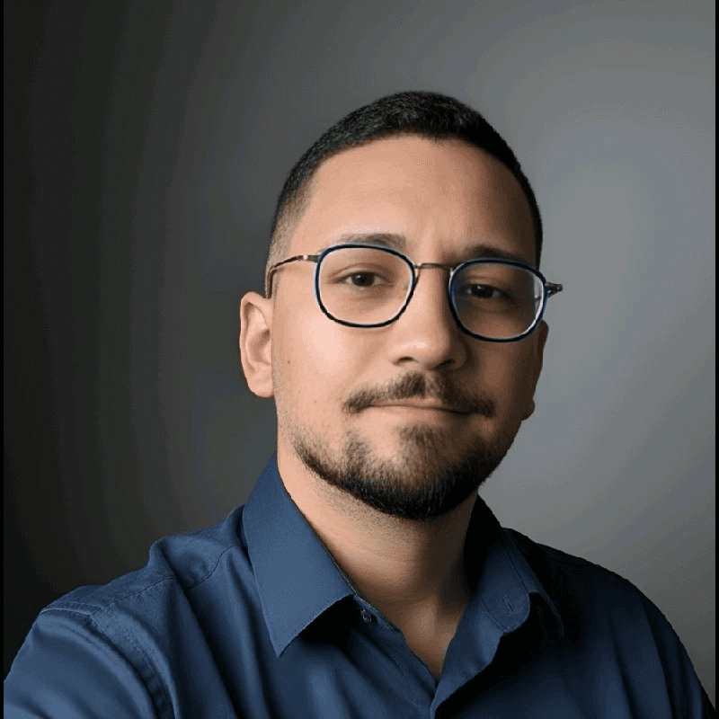 Foto de Clark Silva de perfil, com os olhos fechados. Ele tem óculos redondos, pele clara e cabelos escuros